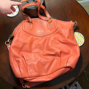 Coral color leather purse, gold hardware, has wear on bottom of bag